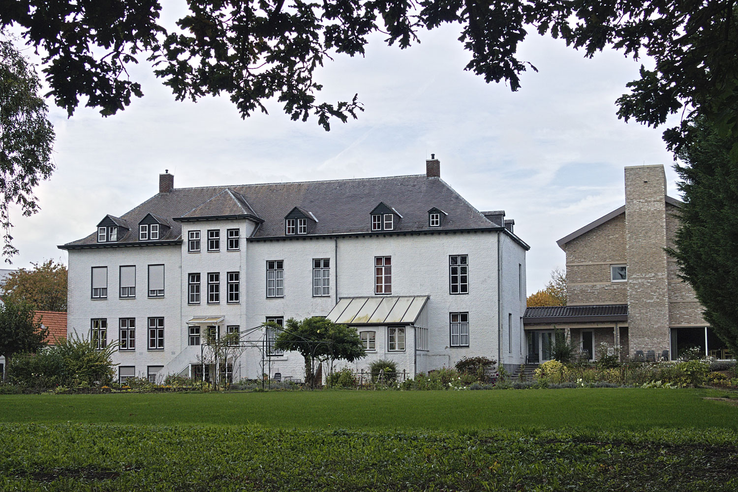 Ons huis gezien van bij het Mariabeeld achter in de tuin.