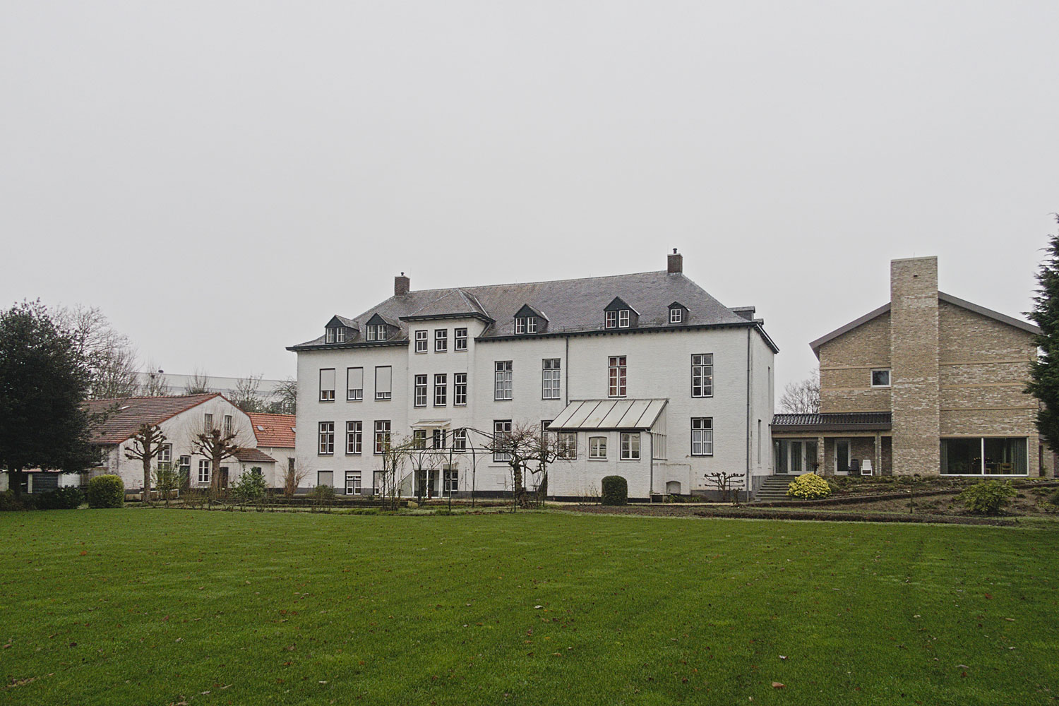 Gelukkig geeft het groene gazon nog wat kleur aan de achtertuin.